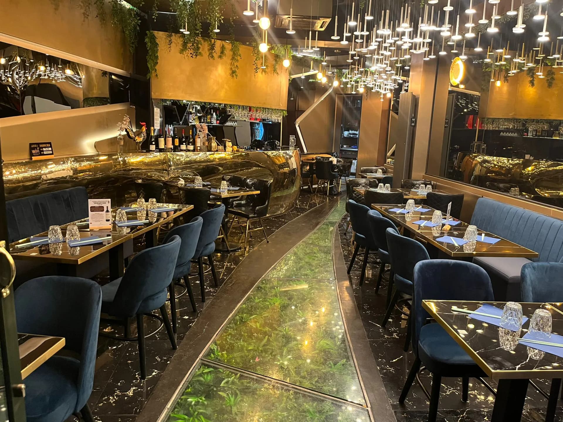 Bar doré sculpté et cascade de cristal du salon Phở 98 à Paris 9e