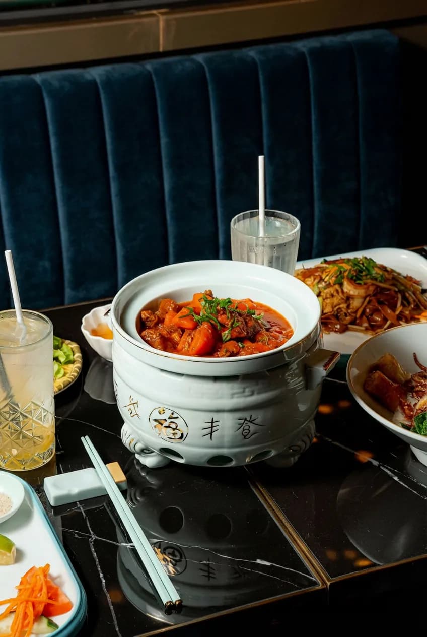 Hot pot on black marble table, velvet banquette in the background